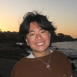 Jared Narvaez smiling by the ocean at sunset